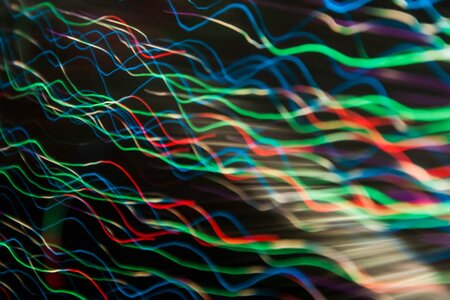 Waves of different coloured light on a black background.
